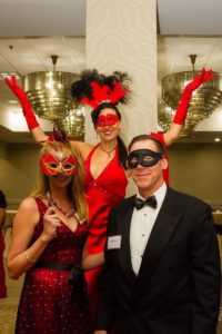 red carpet entertainer with guests at masquerade themed charity gala